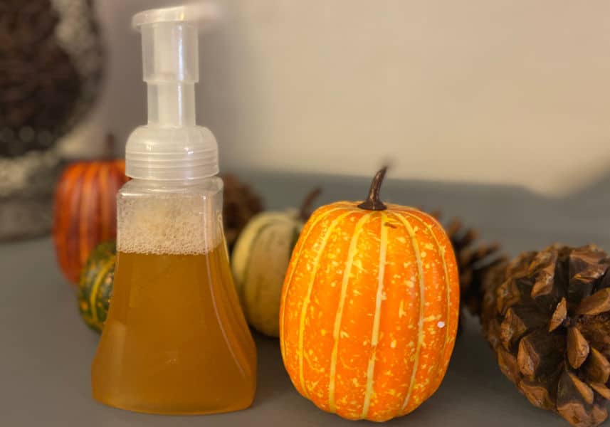 DIY Pumpkin Spice foaming hand soap with pumpkin decor in background.