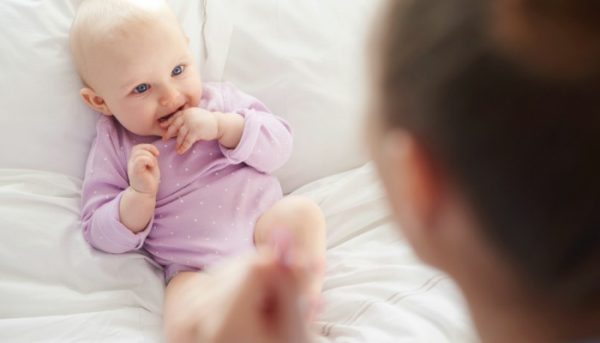 Woman looking down at her smiling baby.