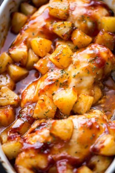 Barbeque chicken with seasoning and pineapple chunks.