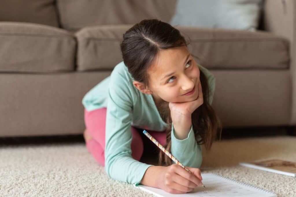 tween girl drawing and smiling.
