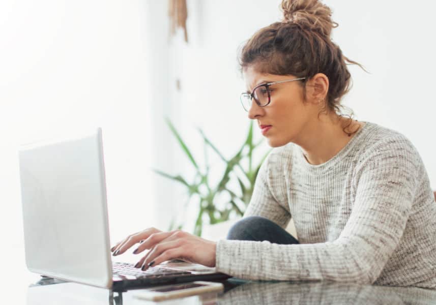 How to become a transcriptionist- transcribing tips. Woman concentrating while working on a laptop.