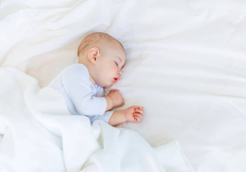 Preparing for baby- sleep tips- 21 days to peace and quiet course illustrated by a sleeping baby on a white crib sheet.