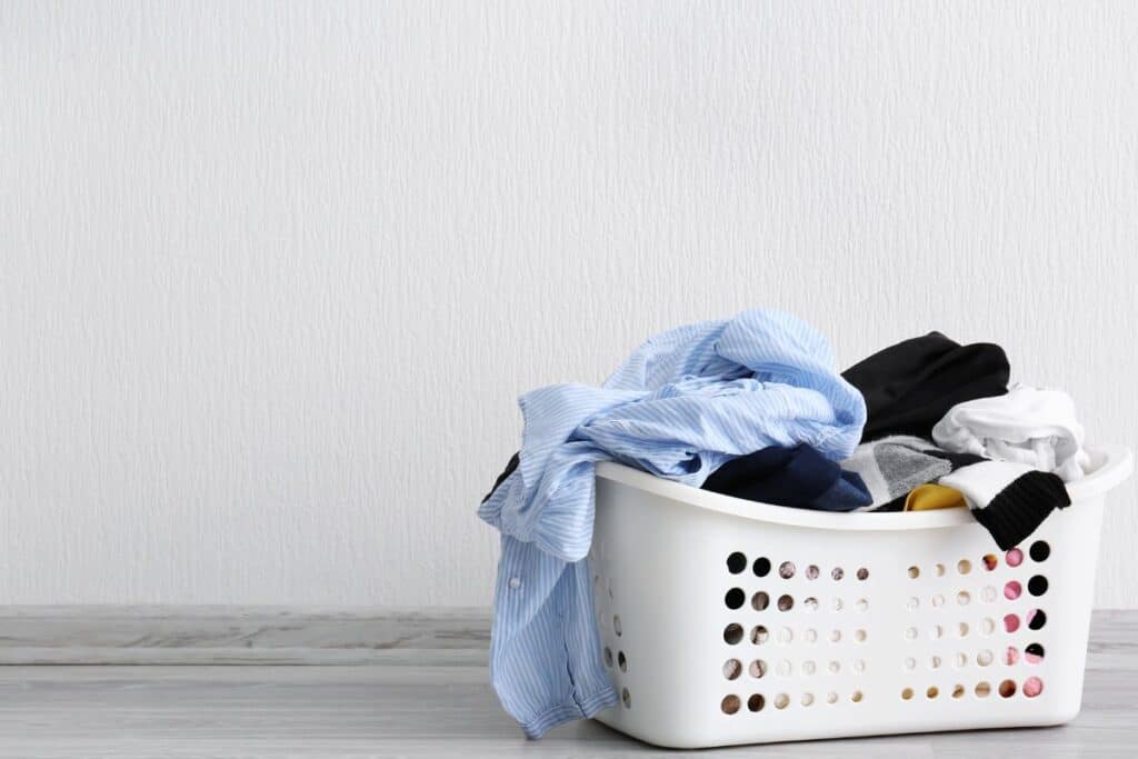 Clean laundry in basket. Exploring homemade laundry detergent versus commercial formulas- featured image