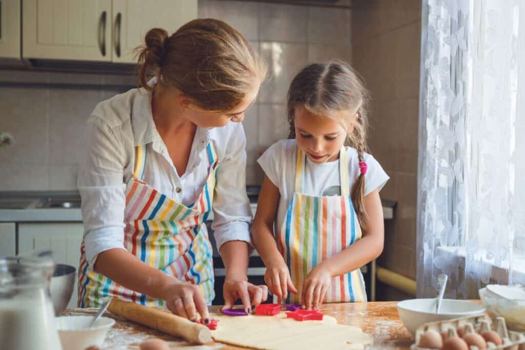 mom baking in kitchen with her little girl.