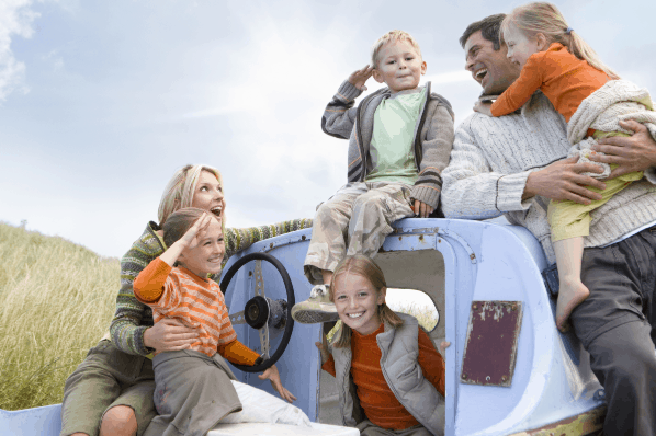Happy Family of six posing outside and playing on an old abandoned boat in a field. Concept of- Having four kids - is having a big family even realistic today?