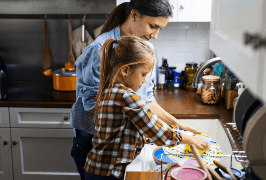 Mom and daughter washing dishes together.