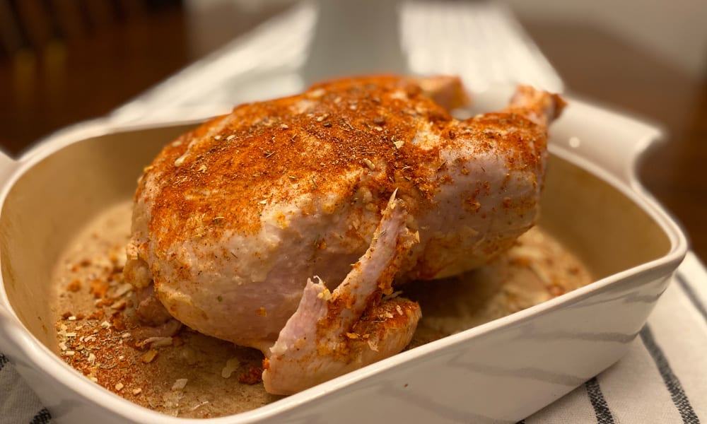 Whole chicken with spices, ready to go into oven.