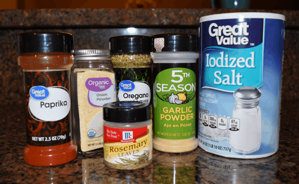 Paprika, onion powder, oregano, garlic powder, salt, and rosemary- image of spices needed for whole roasted chicken recipe.