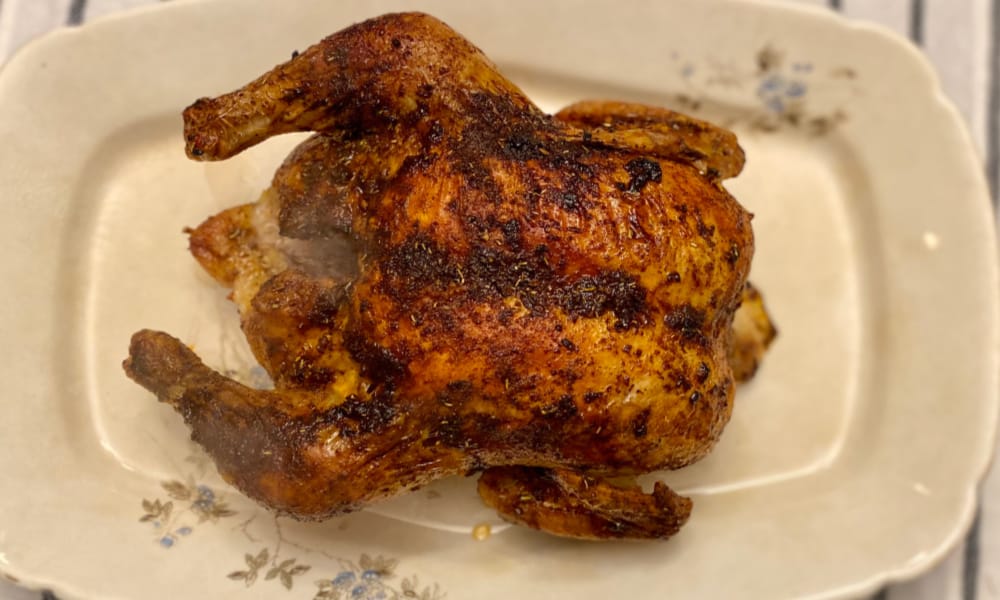 Completed whole roasted chicken recipe on a pretty platter.