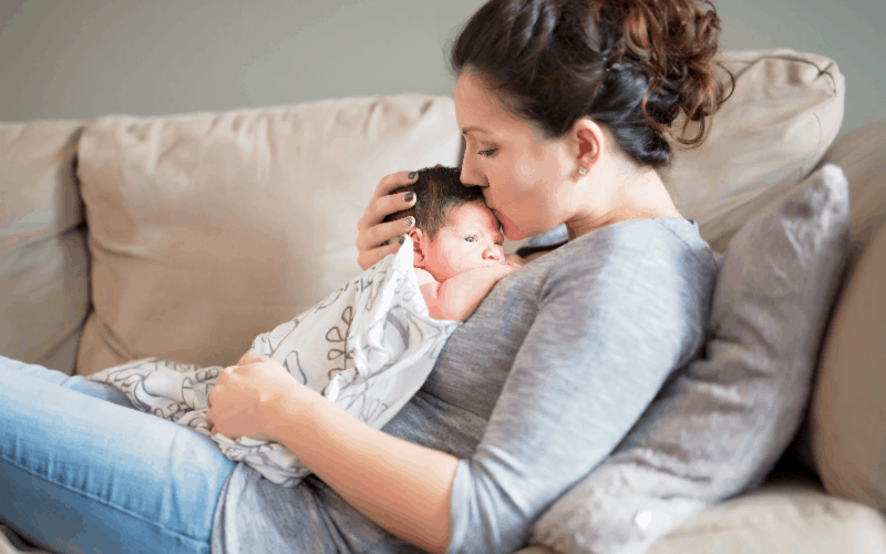 Life with a newborn: Image of mom holding newborn baby on couch