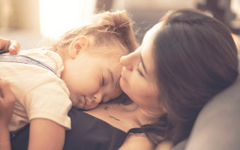 Mother holding sleeping daughter - rewards of parenting