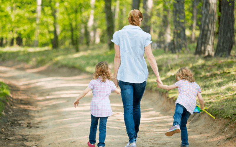 Mother taking walk with children: rewarding parenting moments