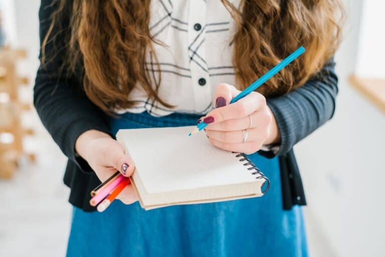 Girl holding notebook and art supplies- back to school concept.