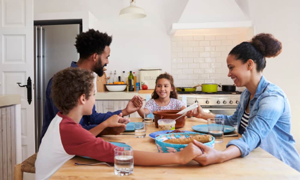 Trusting God with our children (image of family praying over food)