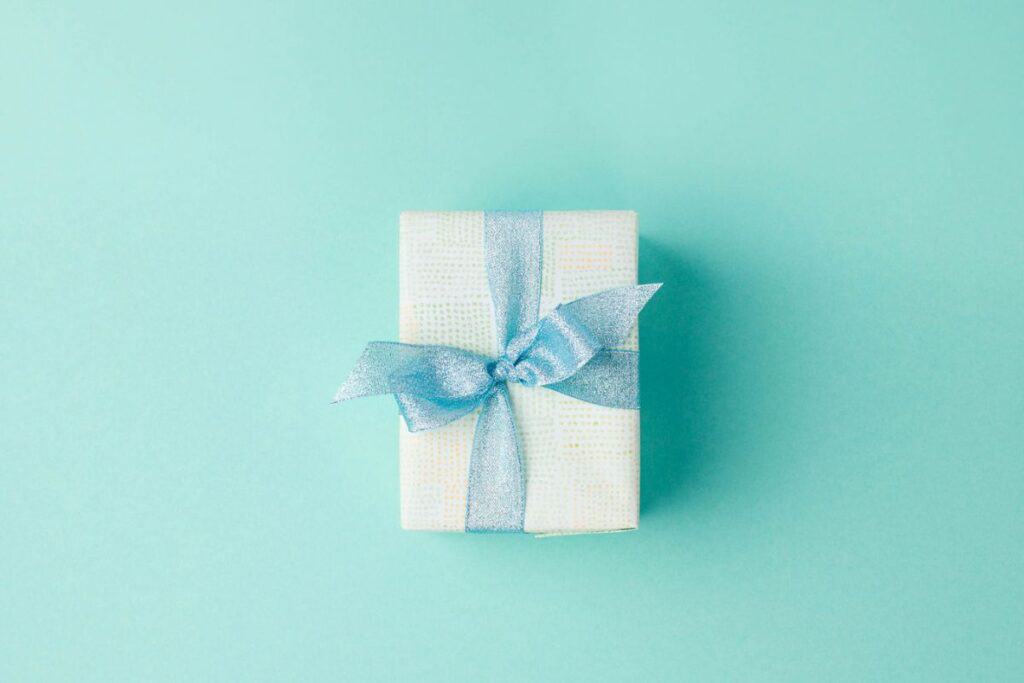Small gift box wrapped with blue ribbon.