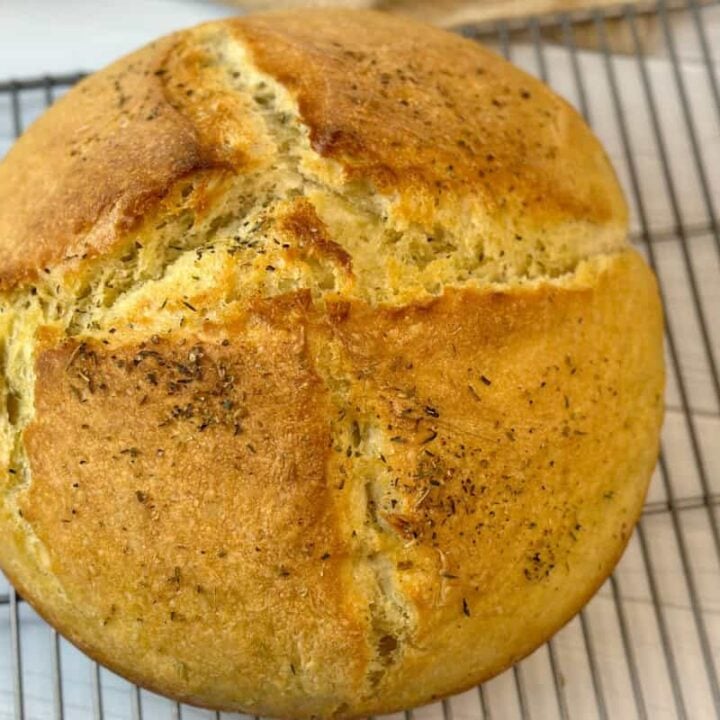 Top view of crusty artisan bread on cooling rack.
