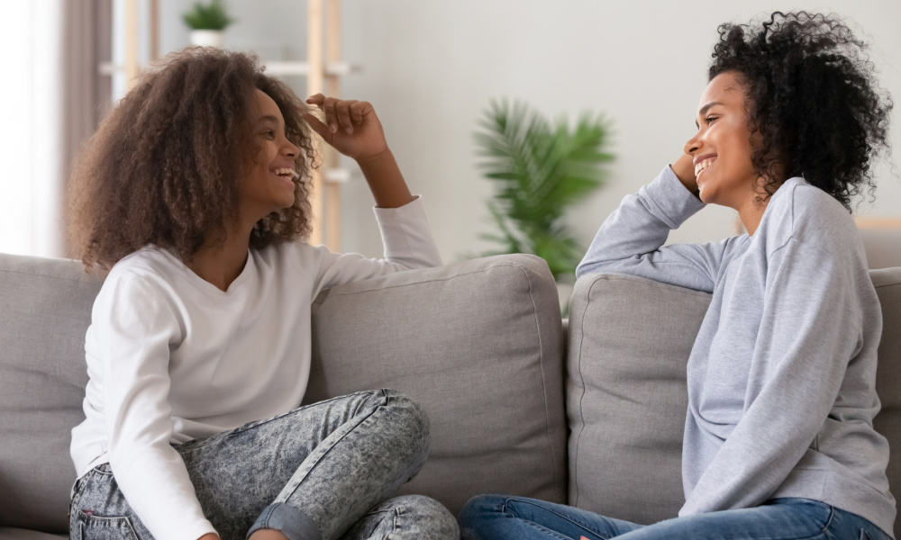 connecting with teenage daughter- mom spending time with daughter on the couch, talking