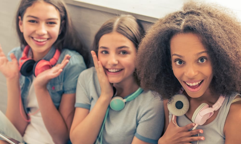 teen girls sitting side by side with headphones