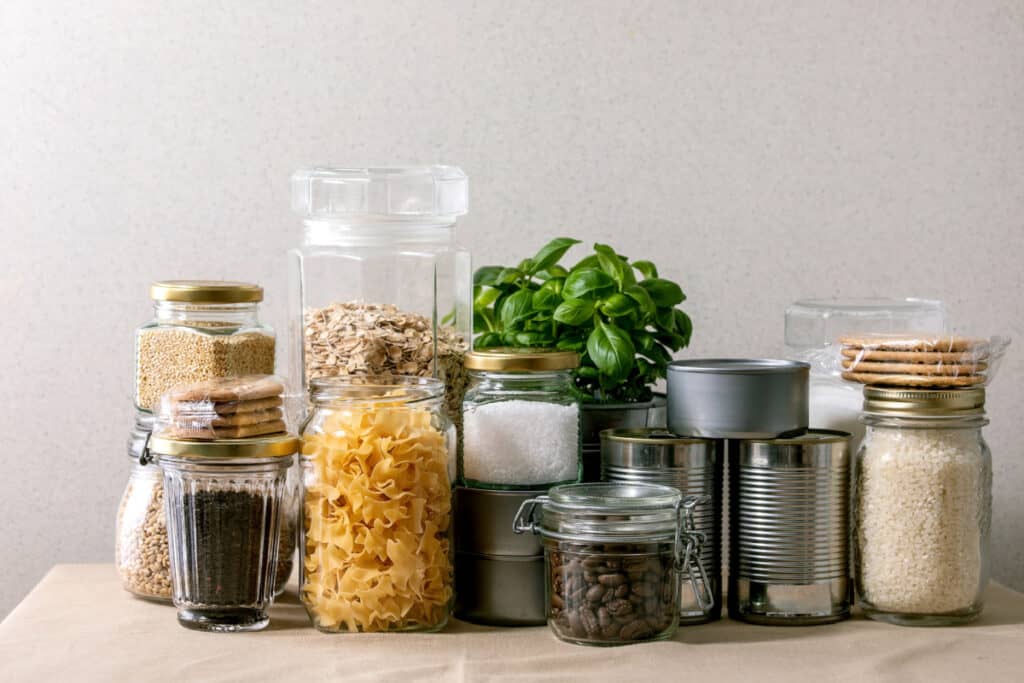 non perishable pantry foods in glass jars and tin cans.