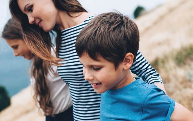 mom with children outdoors, arm in arm.