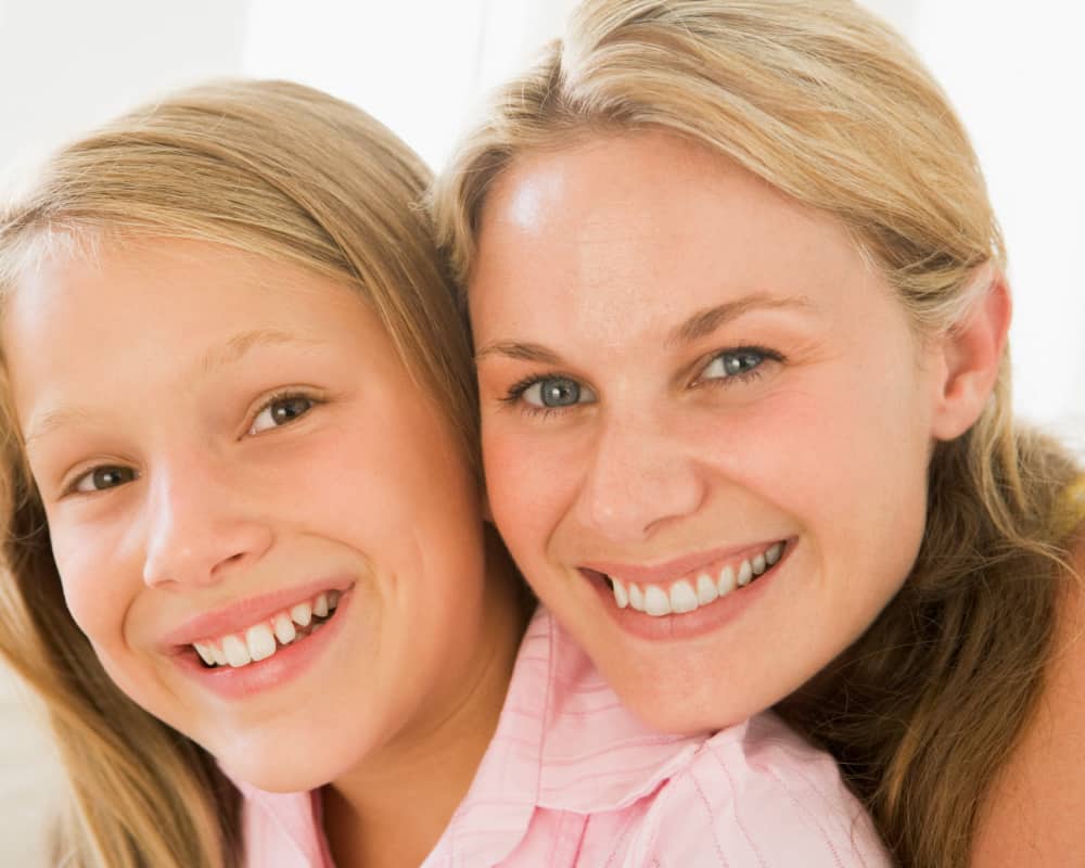 Image of mother resting her chin on daughter's shoulder; concept of spending time with tween daughter