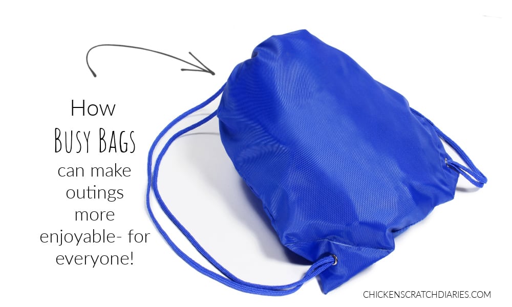 Graphic with a blue drawstring backpack and text - How busy bags can make outings more enjoyable- for everyone! what to put in busy bags for outings with kids.