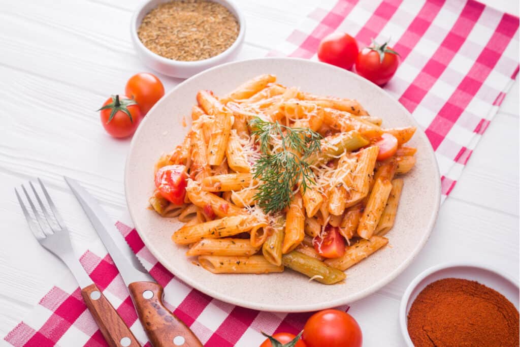 Plate of Rigatoni on a red checked table runner example of summer freezer meals.