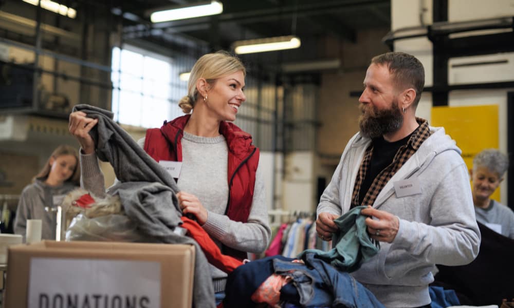 hobbies for moms with a purpose - volunteering: a woman sorts a box labeled "donations" in a warehouse.