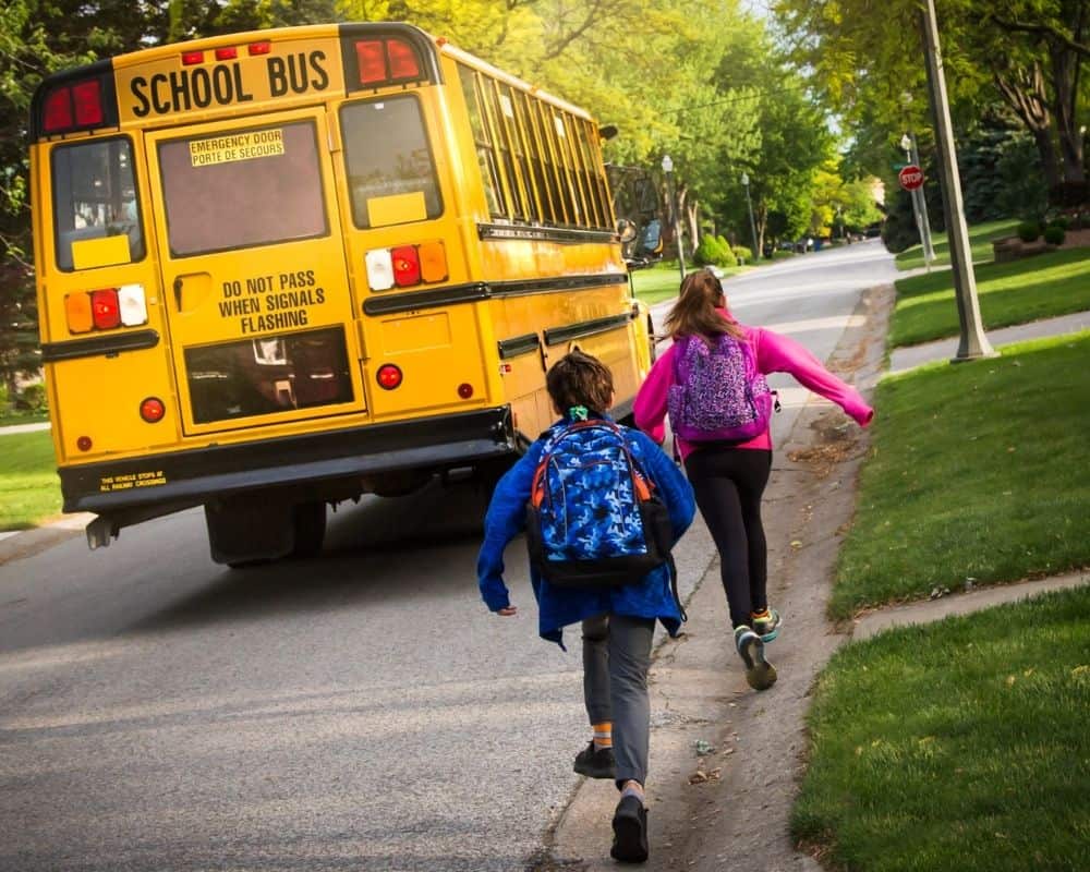 A girl and boy running down sidewalk to catch the bus --Back to school prayer for students in public school