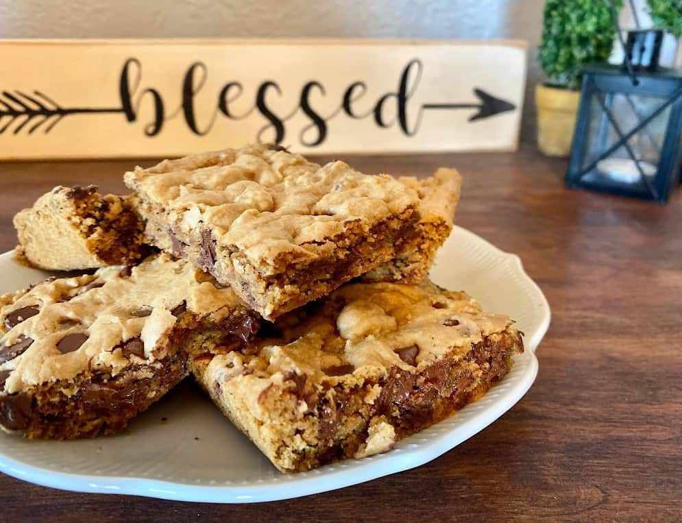 Easy cookie bar recipe with few ingredients: finished bars on a white scalloped-edge plate.