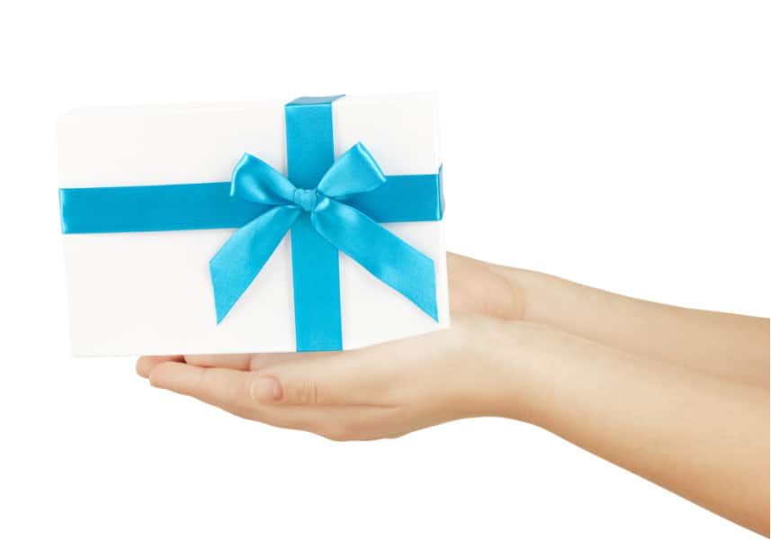 Woman's hands on a white background holding a gift box with a blue ribbon. Useful practical gifts for woman who wants nothing