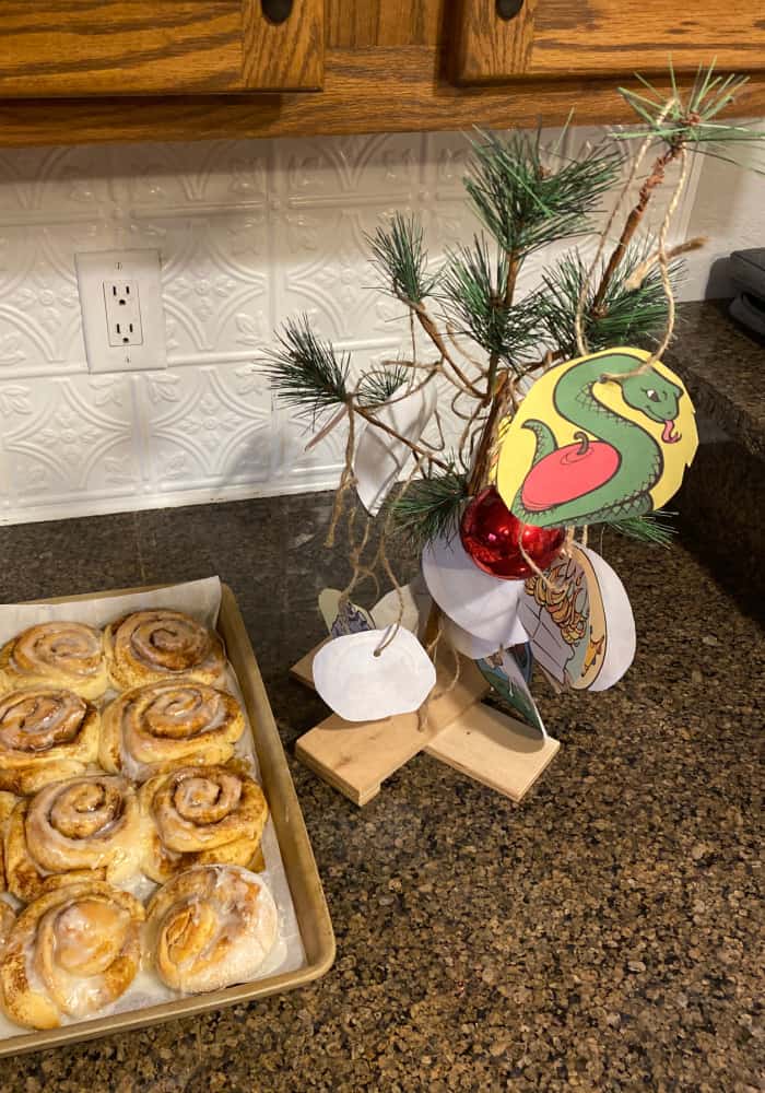 Paper Jesse tree ornaments hanging on a tiny Christmas tree on a kitchen counter.