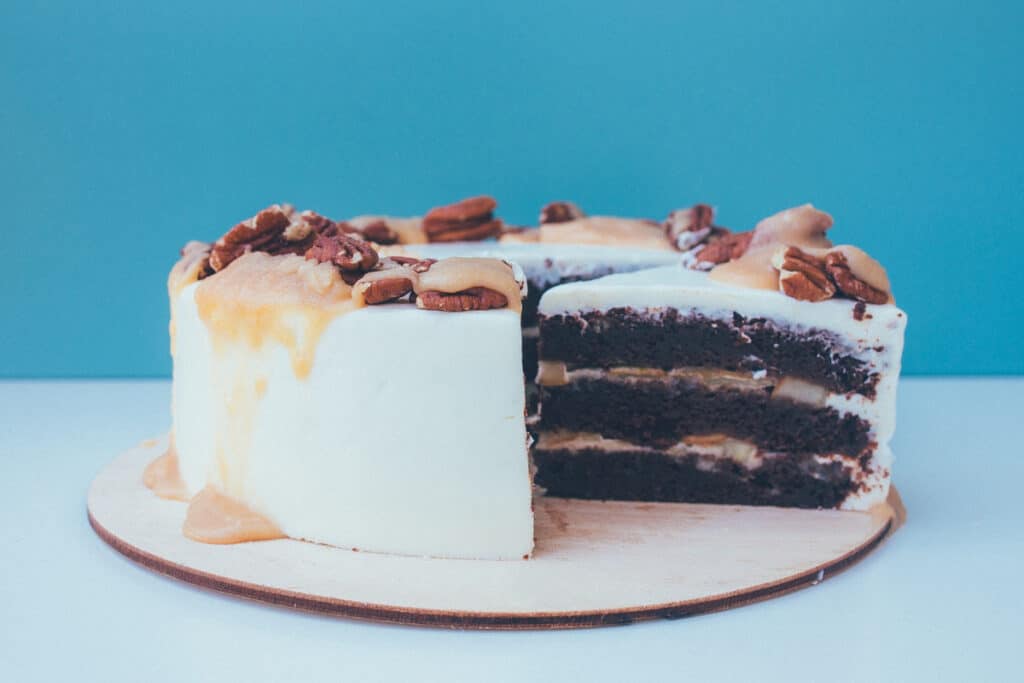 Pecan cake on a platter against a blue background.