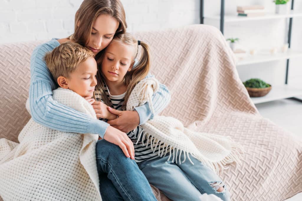 Image of mom huddled with children on a couch: links to article on Scripture for worried moms - below.