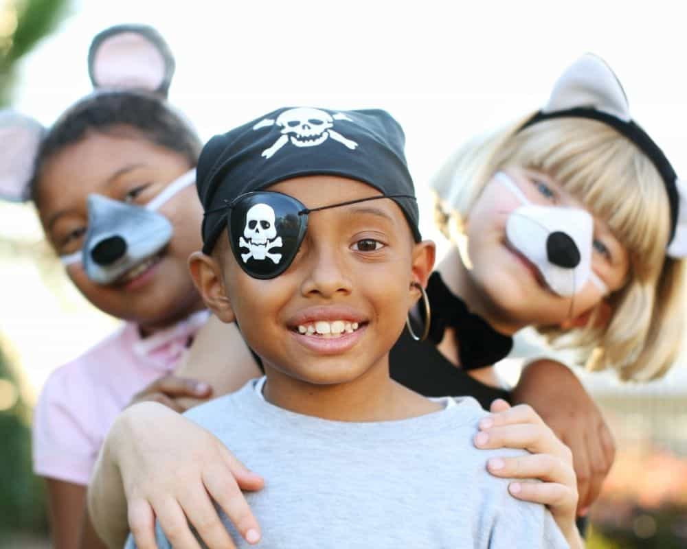 Image of two girls and a boy standing side by side in a mouse, pirate and cat costume.
