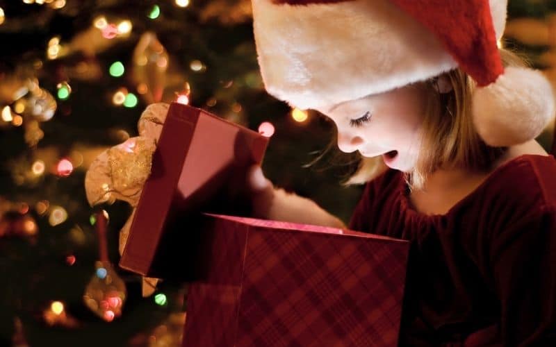 Image of little girl opening Christmas gift