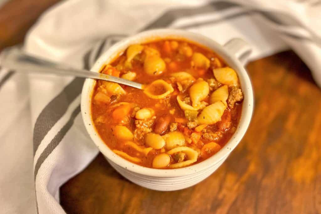 closeup of white mug of pasta e fagioli soup made in Instant Pot.