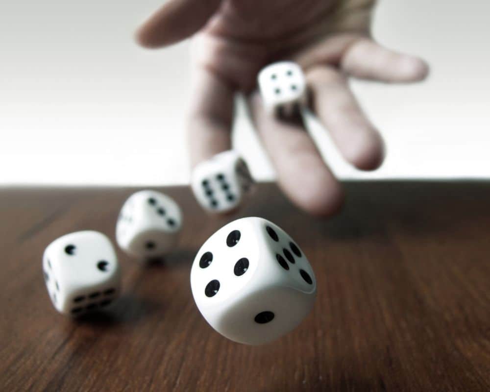 Image of person rolling dice- one of the steps in this free Christmas Trivia game.