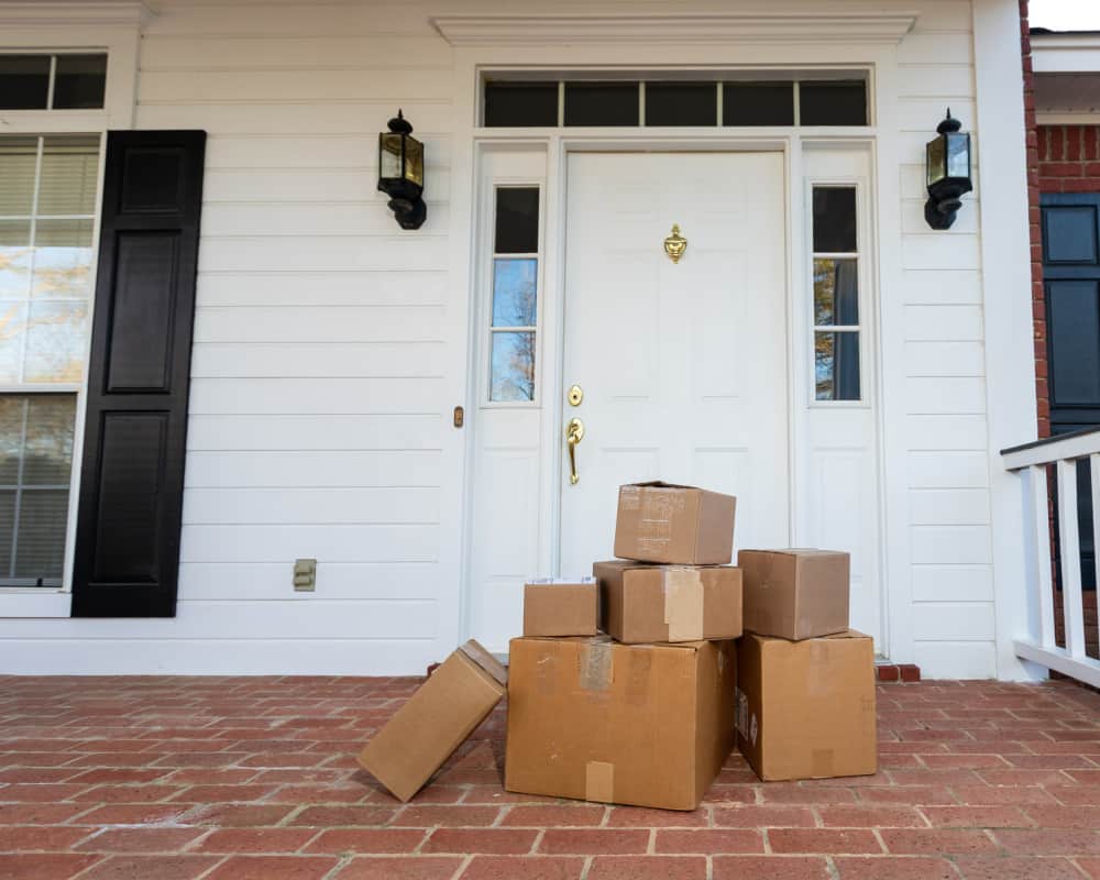 Image of packages on front porch of a house- concept of grocery delivery for big families.