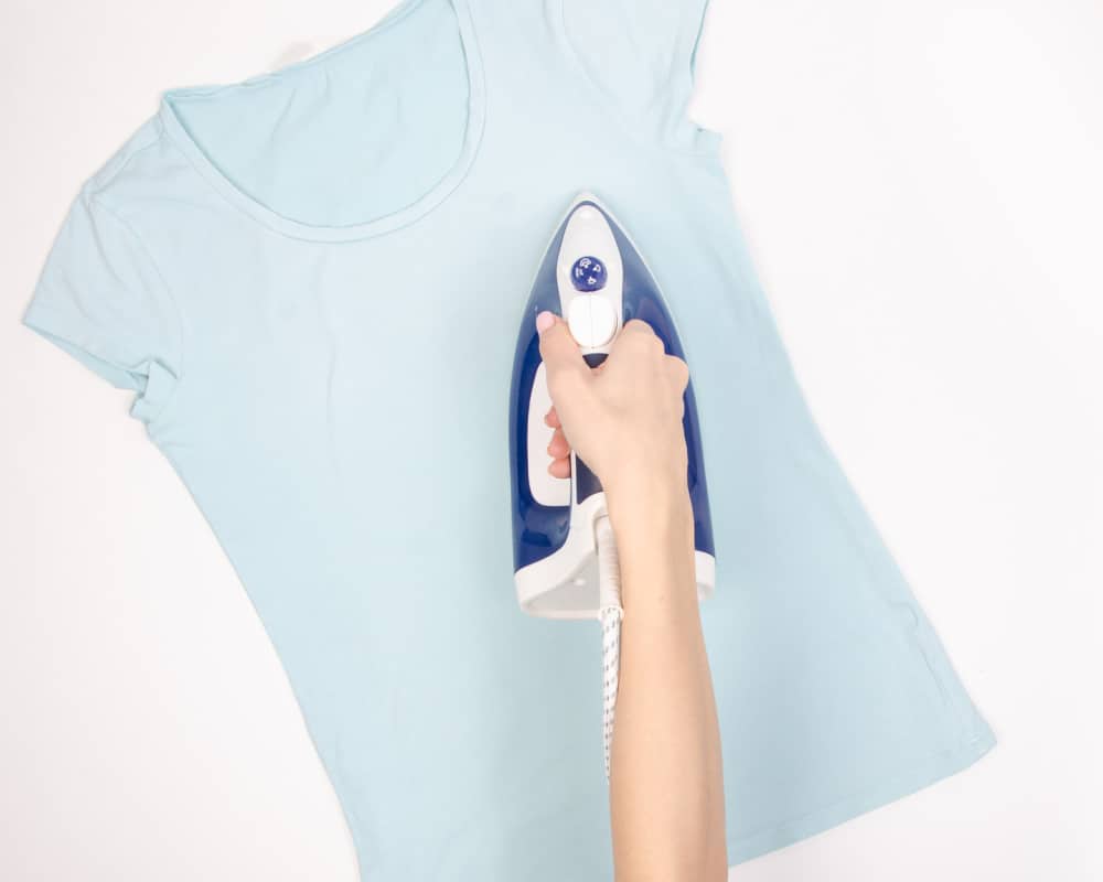Image of ironing a t-shirt. Concept of inspecting clothing for resale online with Facebook Marketplace.