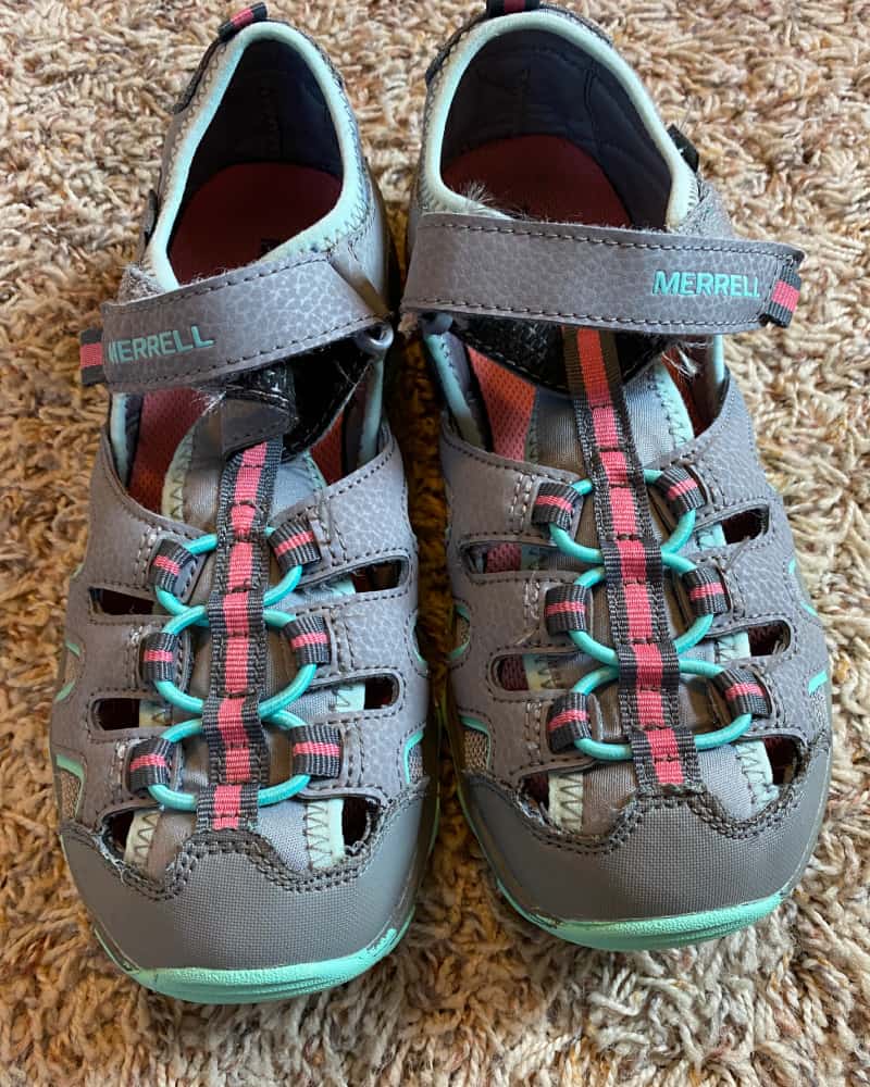 Image of a pair of youth Merrell sandals- green and gray- concept of selling used kids' shoes on Facebook Marketplace.