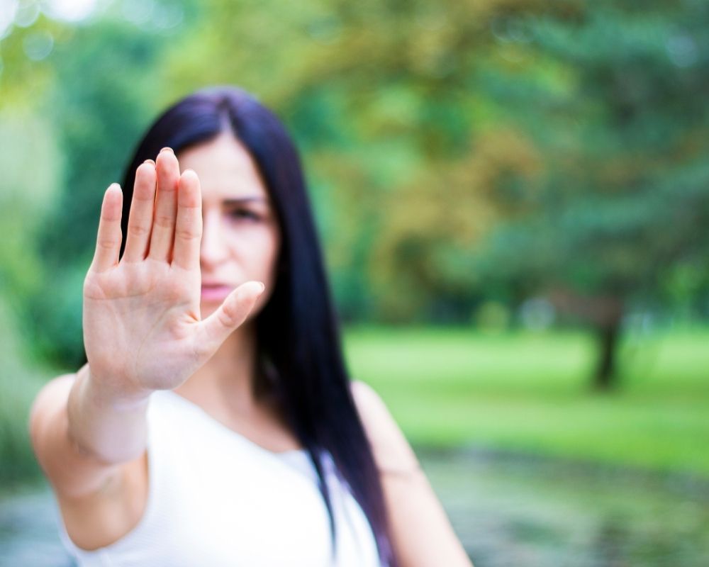 Woman holding up her hand as if saying "no".