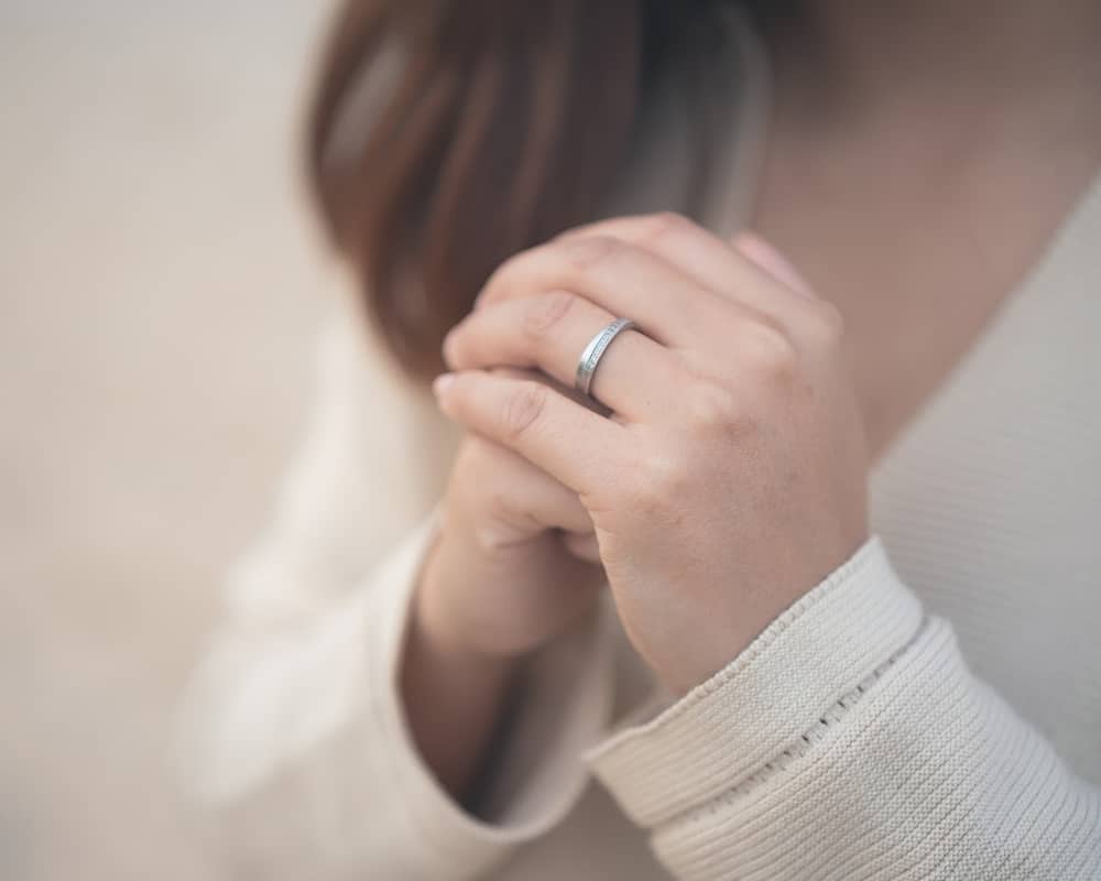 Close-up image of woman praying with hands clasped. Concept of praying for God's strength in setting Christian spiritual goals.