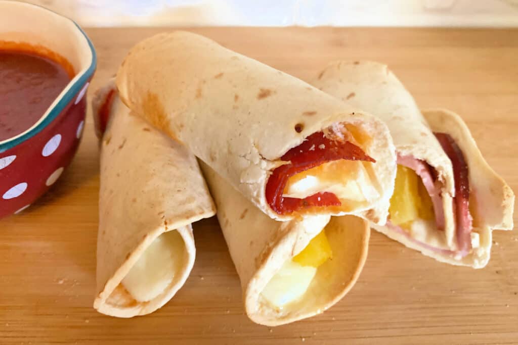 Air fryer pizza roll ups on a wooden surface
