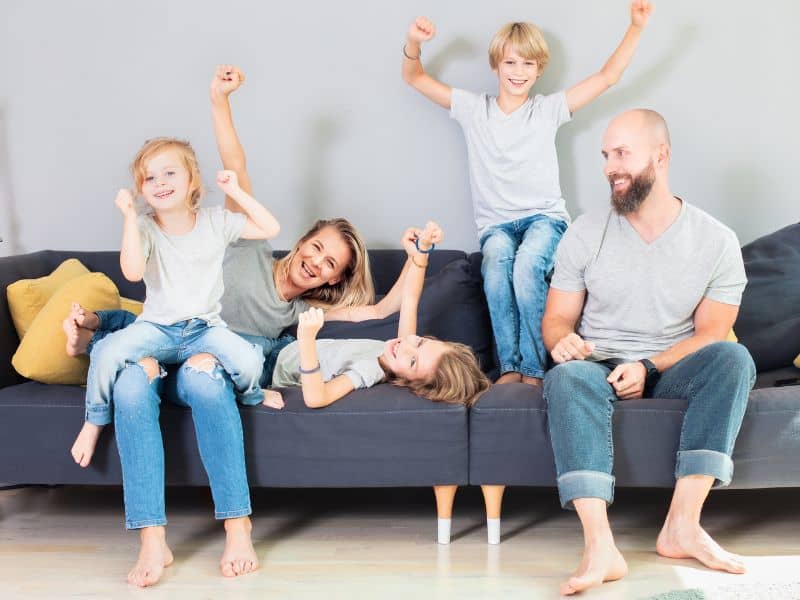 Family connecting and having fun at home on the sofa.