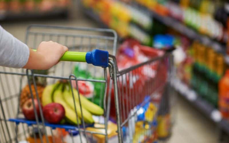 Grocery cart in a store, full of groceries-- stocking up on sale items.