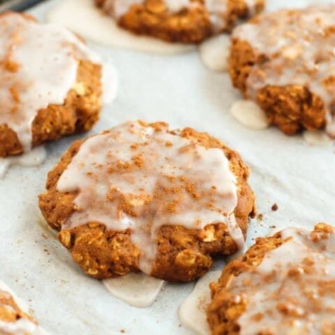 iced oatmeal gingerbread cookies on a baking sheet