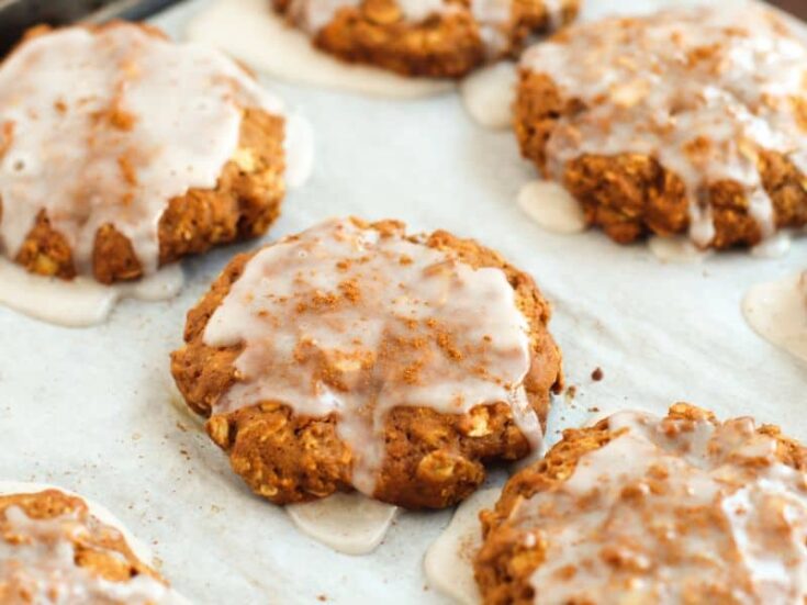 iced oatmeal gingerbread cookies on a baking sheet