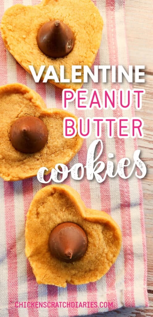 Vertical image of three heart shaped peanut butter cookies on a pink and white striped tea towel, with text overlay "Valentine peanut butter cookies"