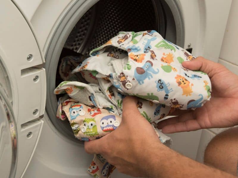 Taking clean cloth diapers out the dryer.